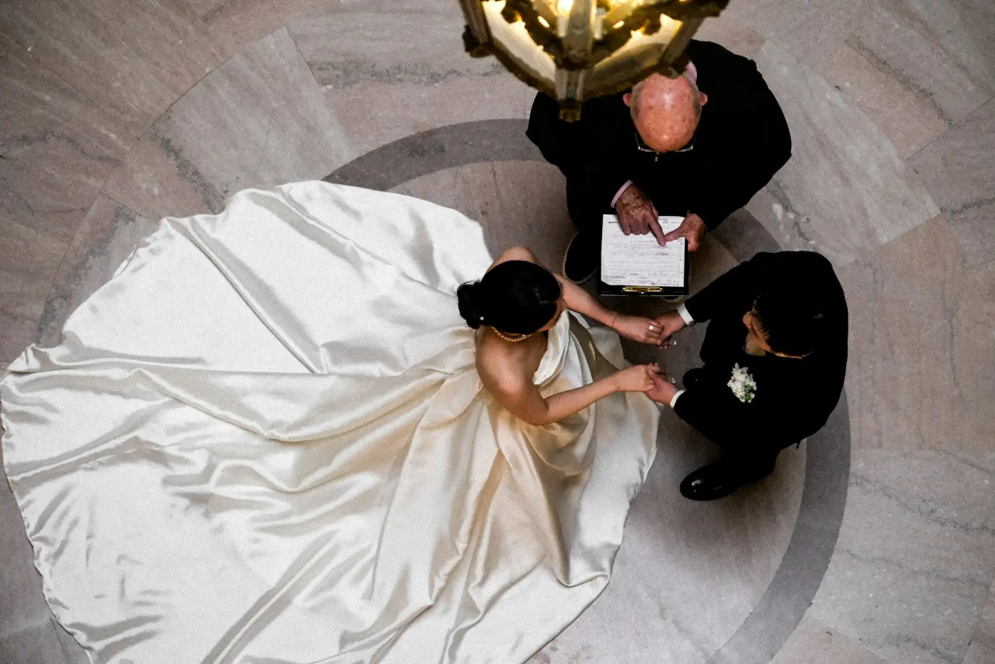 Overhead view of a couple exchanging vows in front of an officiant